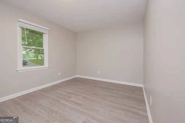 an empty room with wooden floor and a window