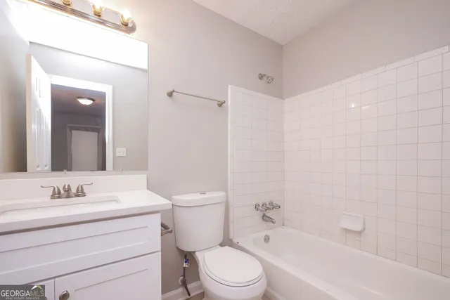 a bathroom with a toilet a sink a mirror a bathtub and shower