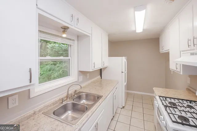 a kitchen that has a sink a window and stainless steel appliances