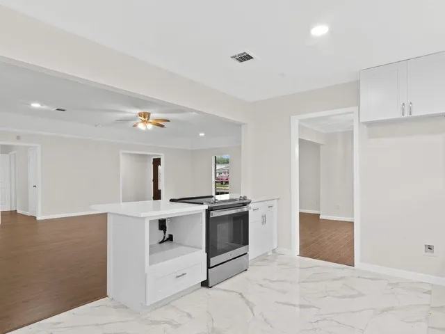 a kitchen with kitchen island a stove a sink and a refrigerator