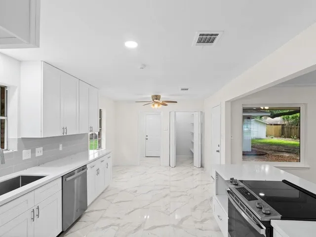 a kitchen with stainless steel appliances a stove a sink and a refrigerator