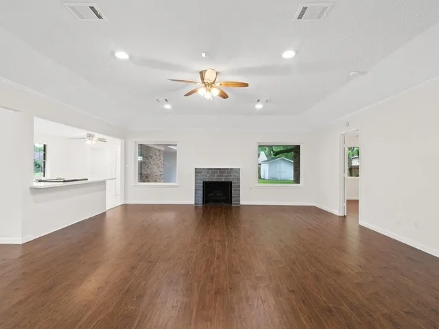 an empty room with wooden floor fireplace and mountain view