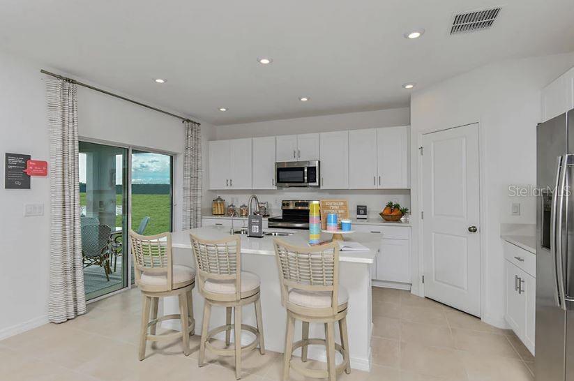13815 Sawmill Street Parrish, FL 34219 - Photo 12 of 25 a kitchen with stainless steel appliances granite countertop a refrigerator and a stove top oven