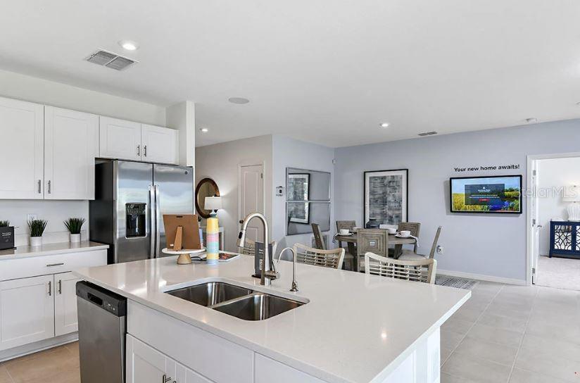 13815 Sawmill Street Parrish, FL 34219 - Photo 13 of 25 a kitchen with cabinets a sink and a refrigerator