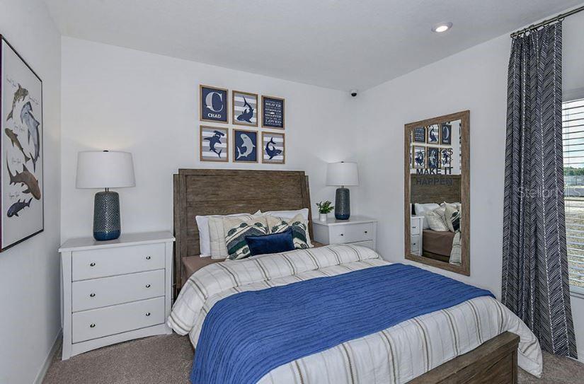 13815 Sawmill Street Parrish, FL 34219 - Photo 9 of 25 a bedroom with a large bed and a tv