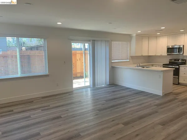 a view of kitchen with granite countertop cabinets wooden floor and a sink
