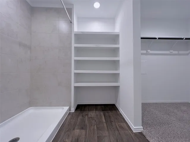 a view of walk in closet with empty racks