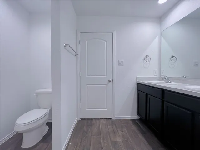 a bathroom with a sink a toilet a shower and a window