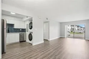 a view of a kitchen with a sink oven window and wooden floor