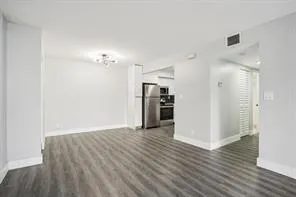 a view of a kitchen with a sink refrigerator and wooden floor