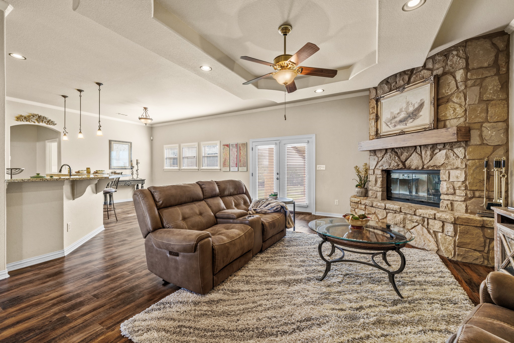 204 Skyline Road Georgetown, TX 78628 - Photo 13 of 40 Living room featuring dark wood-type flooring, recessed lighting, a ceiling fan, a stone fireplace, and french doors