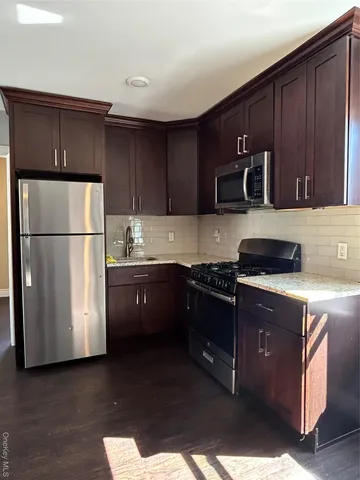 a kitchen with stainless steel appliances granite countertop a refrigerator a stove a sink and a microwave