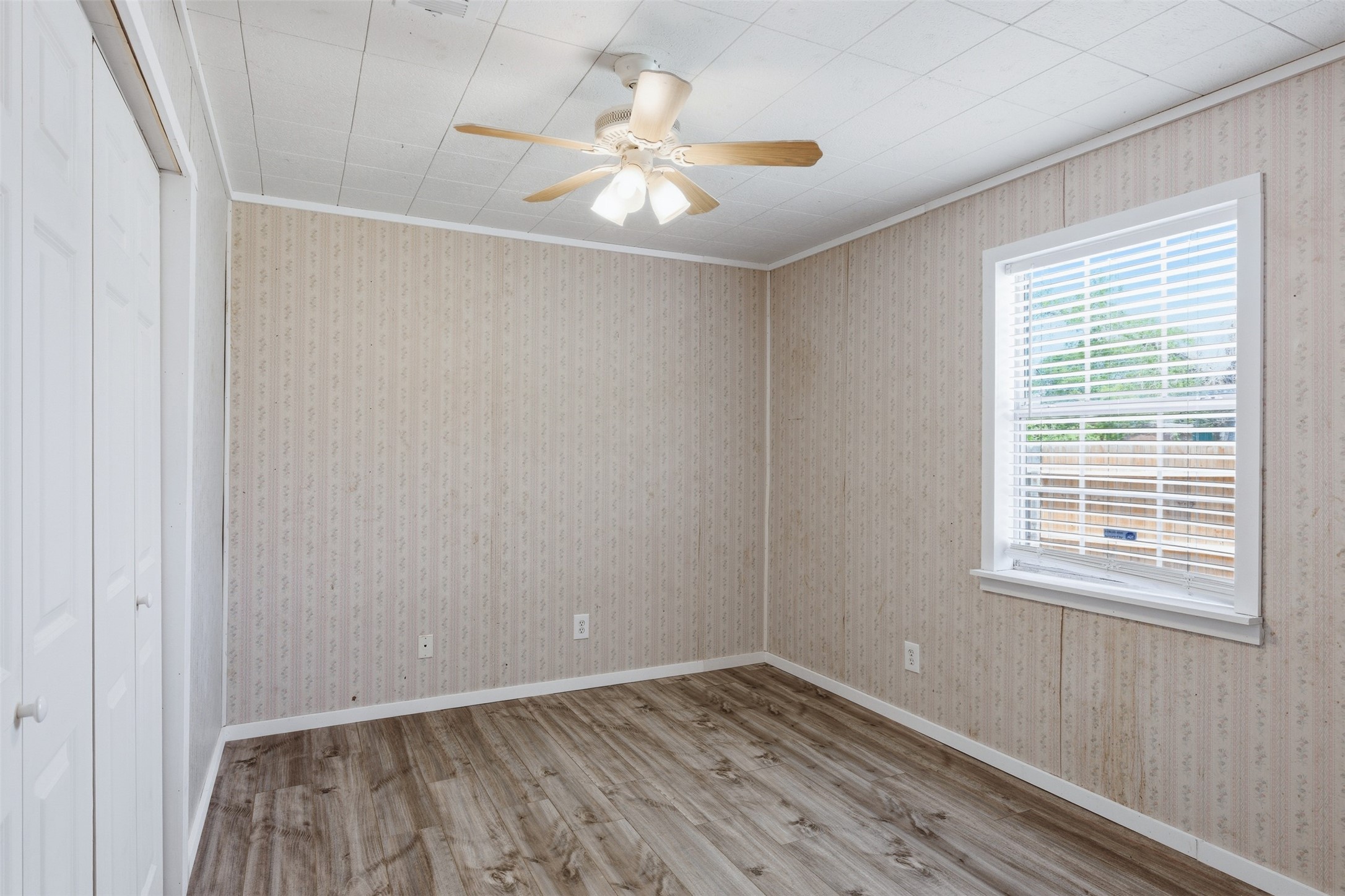 1310 Brazos Street Hempstead, TX 77445 - Photo 18 of 32 a view of an empty room with wooden floor and a window