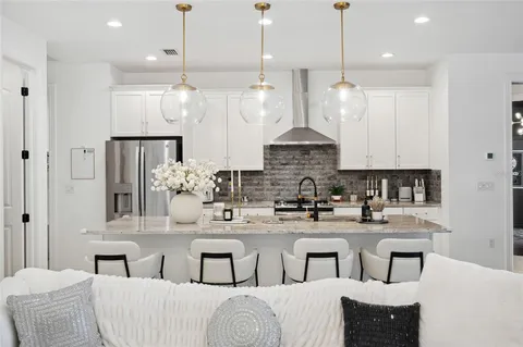 a kitchen with stainless steel appliances kitchen island granite countertop a sink and a refrigerator