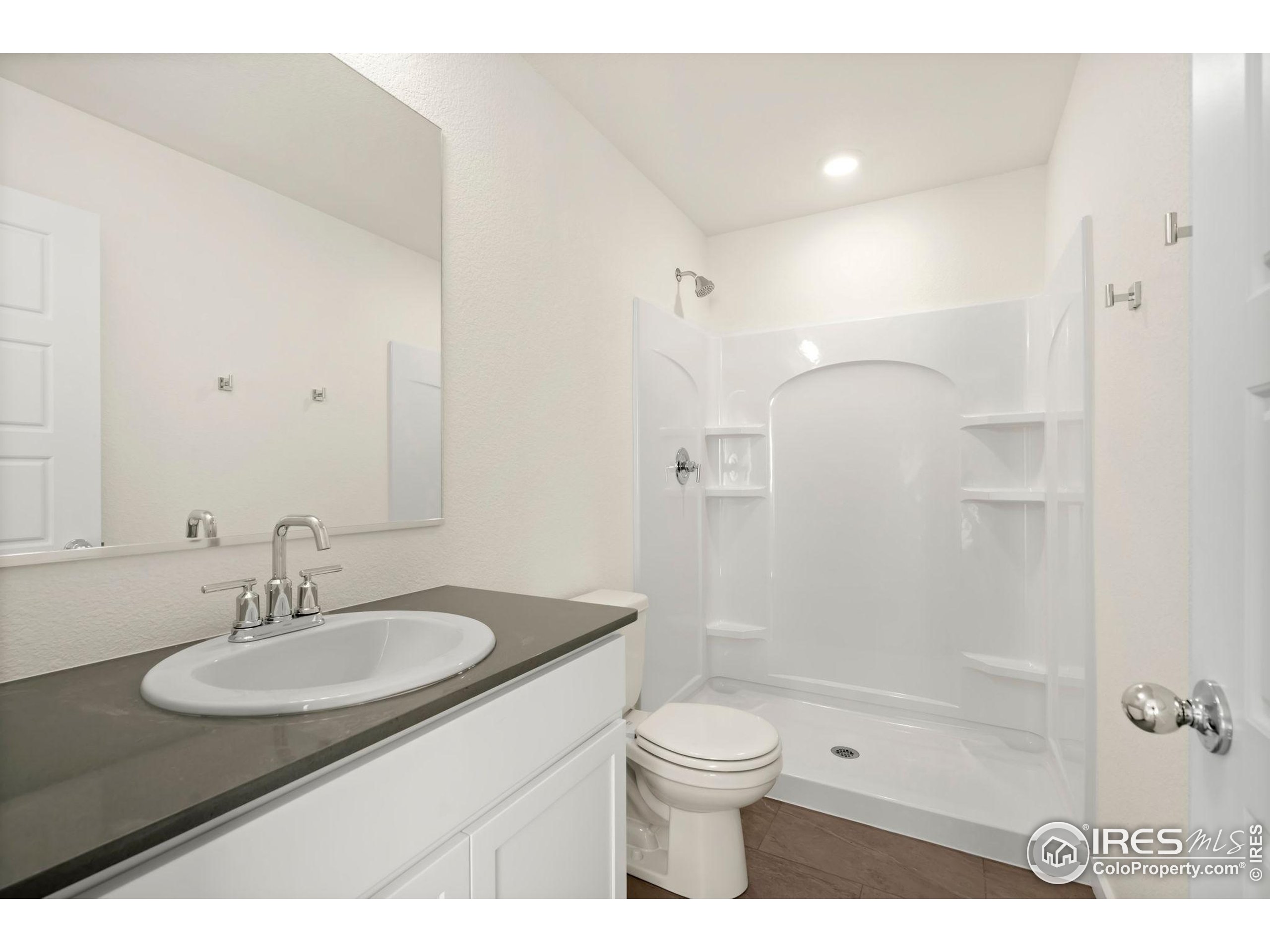 3904 Net Street Evans, CO 80620 - Photo 13 of 14 a bathroom with a sink toilet a shower and a mirror