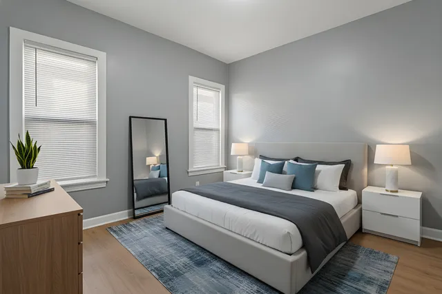 a bedroom with a bed and a potted plant on the dresser