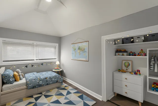 a bedroom with baby bed and window