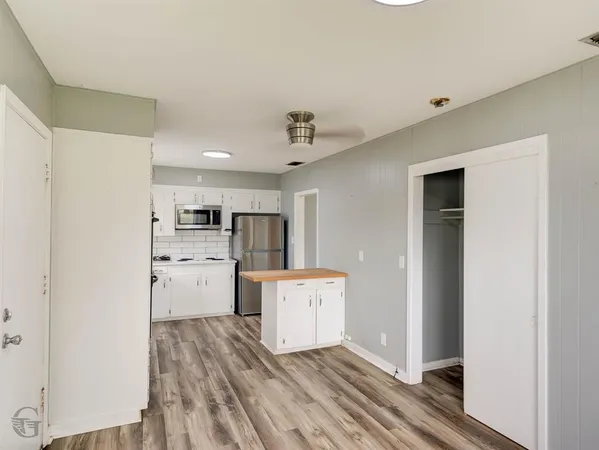 a kitchen with refrigerator cabinets and wooden floor