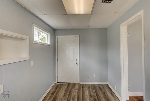 a view of a room with wooden floor and a window