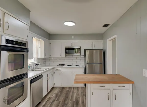 a kitchen with a sink stove and refrigerator