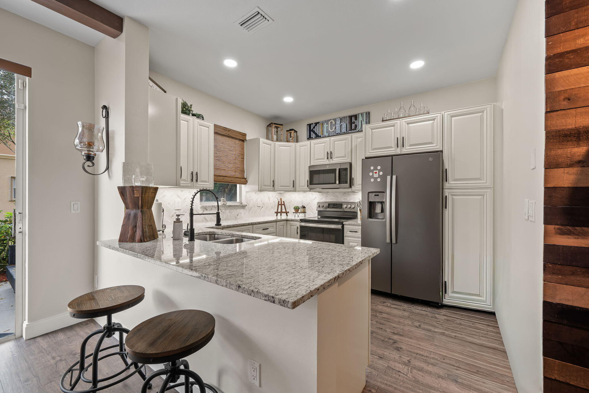 123 Wakulla Springs Way Royal Palm Beach, FL 33411 - Photo 14 of 27 a kitchen with stainless steel appliances granite countertop a refrigerator a sink a stove a dining table and chairs