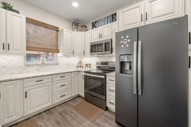 a kitchen with cabinets stainless steel appliances and a window
