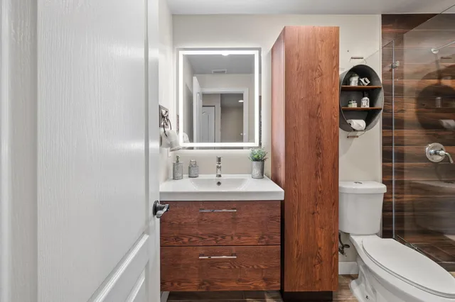 a bathroom with a sink a toilet and shower