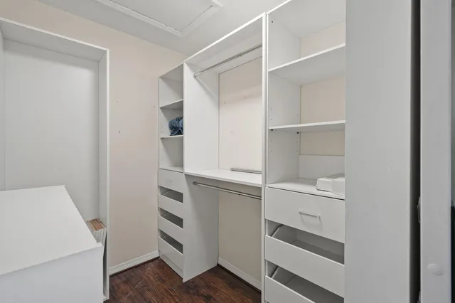a kitchen with white cabinets and wooden floor