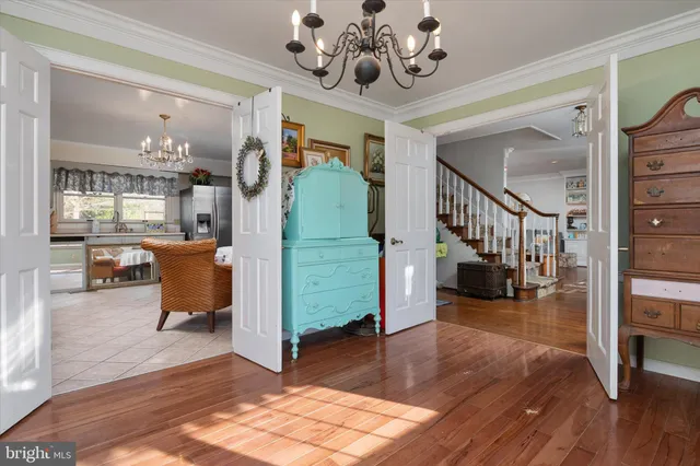 a view of a hallway with dining room and wooden floor