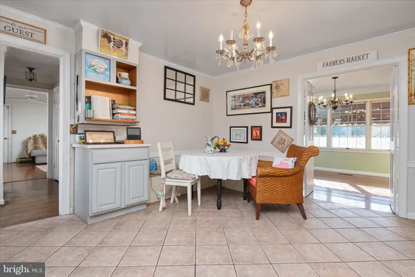 a living room with furniture a chandelier and a dining table