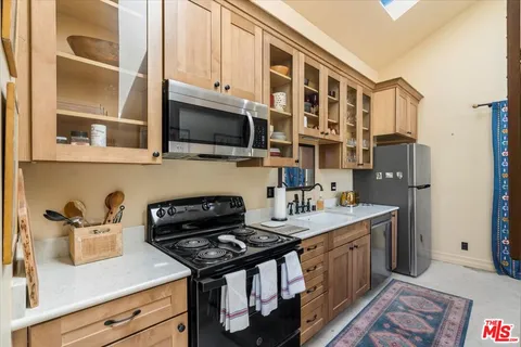 a kitchen with stainless steel appliances granite countertop a stove a sink and a microwave