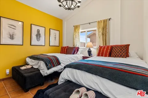 a bedroom with two beds and painting on the wall
