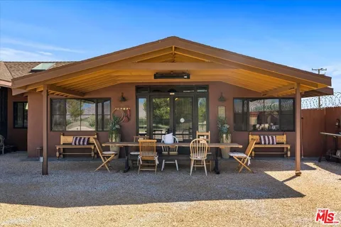 a view of a patio with table and chairs and floor to ceiling window