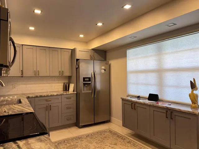a kitchen with stainless steel appliances granite countertop a refrigerator and a sink