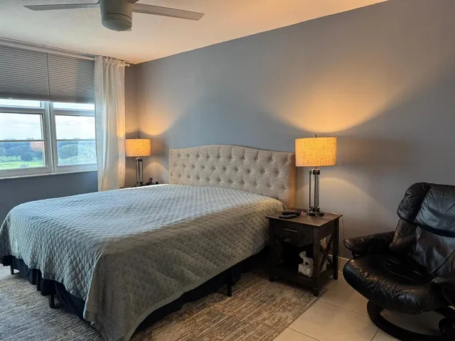 a bedroom with a bed and a lamp on dresser