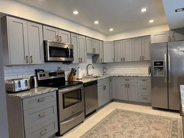 a kitchen with stainless steel appliances granite countertop a stove and a microwave