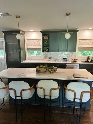 a kitchen with a dining table chairs and white cabinets