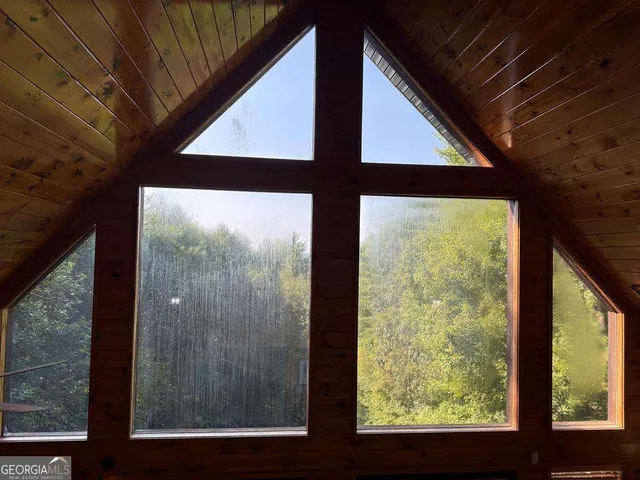a living room with furniture a rug and a floor to ceiling window