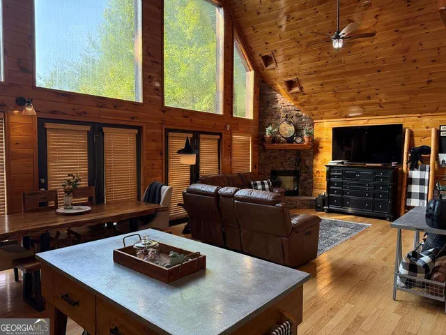 a living room with furniture flat screen tv and a large window