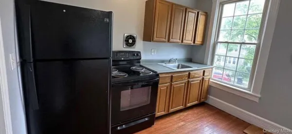 a kitchen with a stove a refrigerator and a window