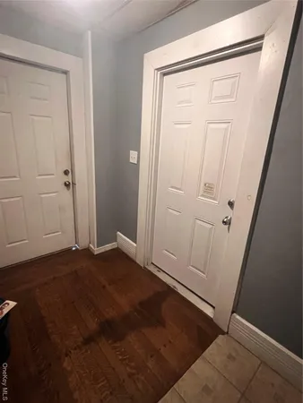 an empty room with wooden floor and mirror