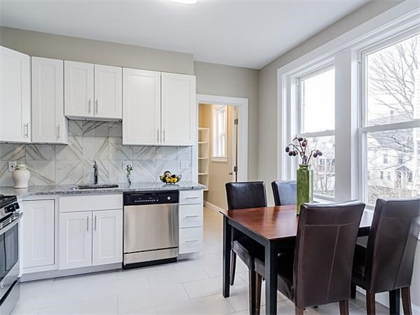 a kitchen with a table chairs sink and cabinets