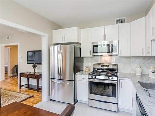 4 Leicester Street, Unit 4 Boston, MA 02135 - Photo 2 of 12 a kitchen with refrigerator a stove a microwave and cabinets