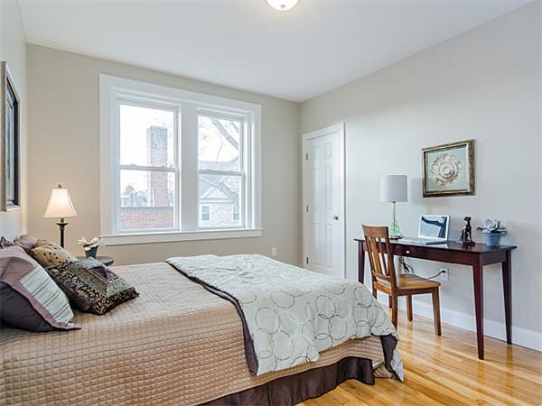 4 Leicester Street, Unit 4 Boston, MA 02135 - Photo 7 of 12 a bedroom with a bed a table and chair with a large windows