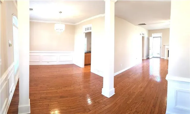 a view of empty room with wooden floor