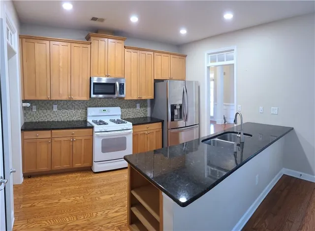 a kitchen with kitchen island granite countertop a stove sink and refrigerator