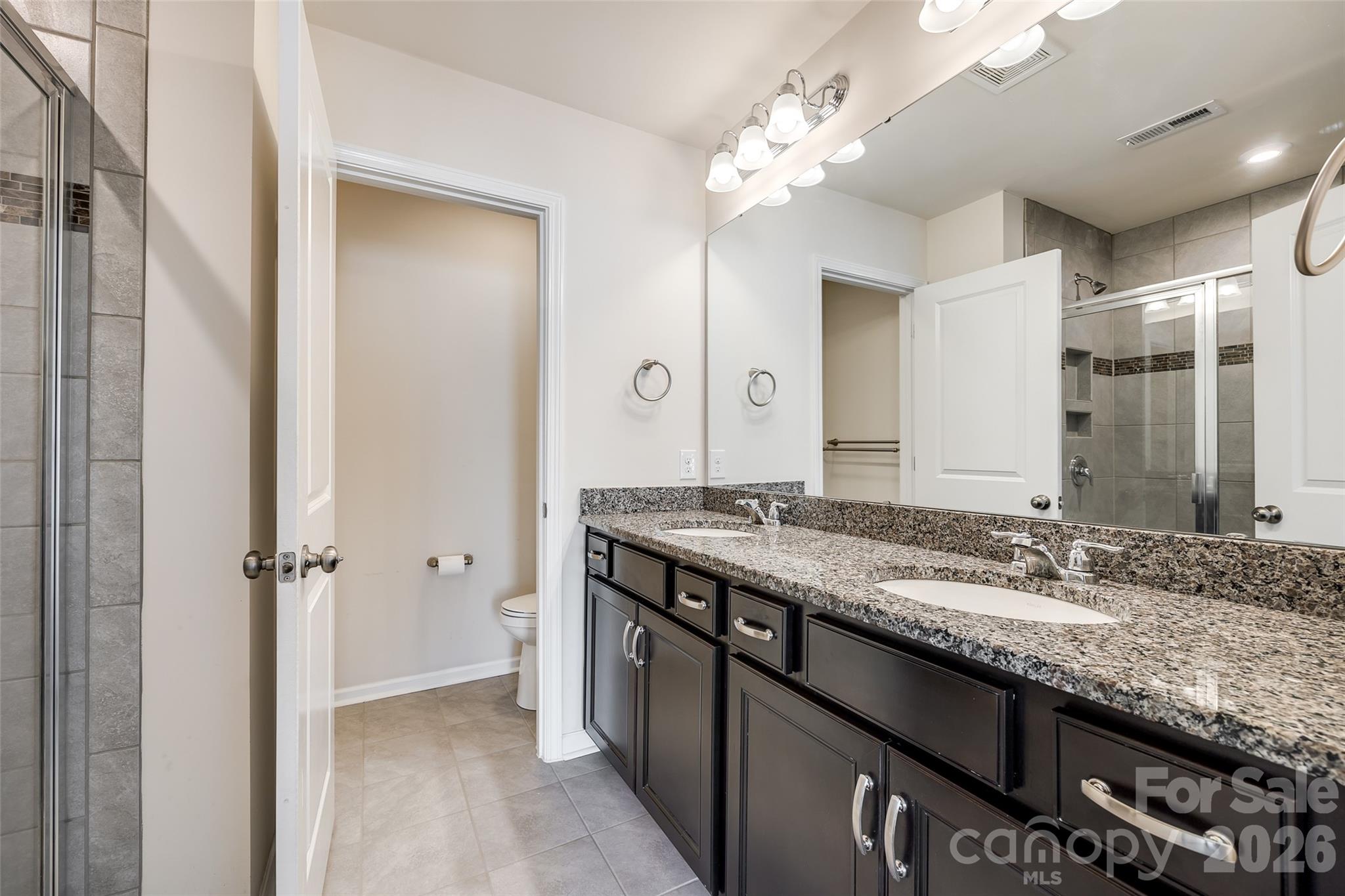 524 Hunters Dance Road Fort Mill, SC 29708 - Photo 10 of 34 a bathroom with a granite countertop sink a large mirror and a shower