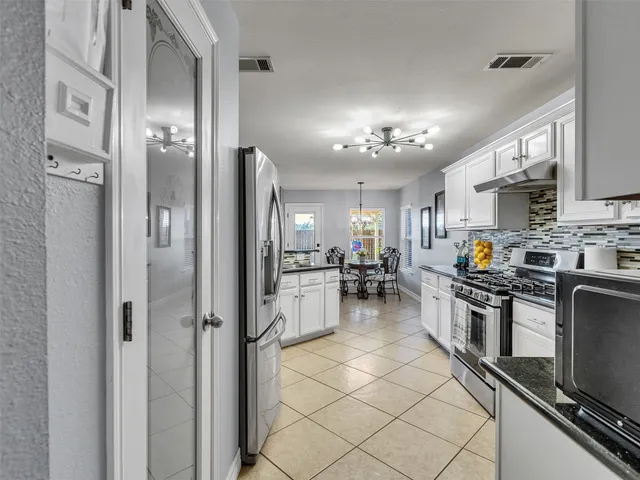 a kitchen with refrigerator and cabinets