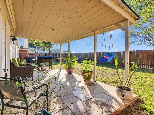 a view of a patio with table and chairs potted plants