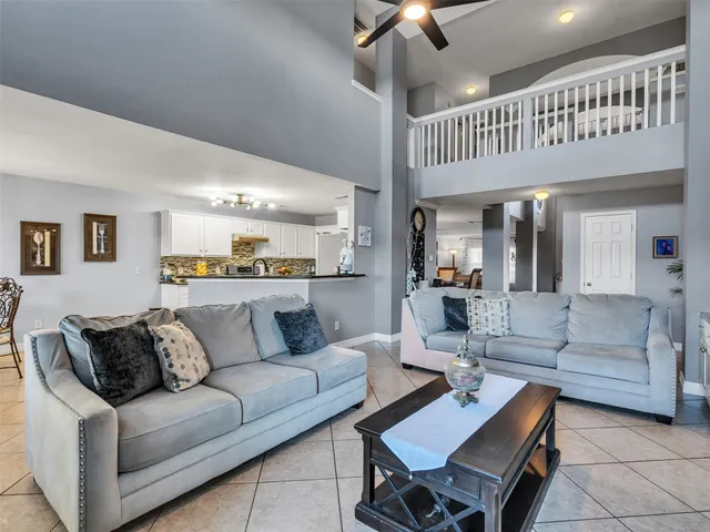 a living room with furniture and a ceiling fan